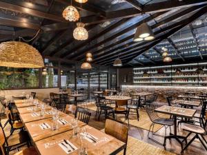 a restaurant with tables and chairs and a bar at Mercure Pont d’Avignon Centre in Avignon