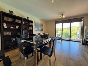 a dining room with a glass table and black chairs at Apartamento El Abuelo en Cangas de Onís in Cangas de Onís
