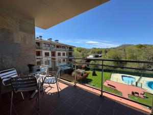 a balcony with a table and chairs and a pool at Apartamento El Abuelo en Cangas de Onís in Cangas de Onís