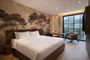 ein Schlafzimmer mit einem großen Bett und einem großen Fenster in der Unterkunft RIN Hotel Da Lat in Xuan An