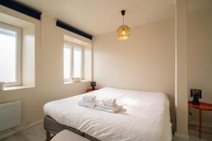 a bedroom with a bed with towels on it at Le Cocon Alsacien - Rez de chaussée - Parking privé in Ebersheim