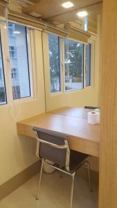 a desk with a chair in a room with windows at Suntrust Parkview Apartment in Manila