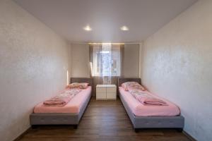 two beds in a room with a window at Müller´s Talblick in Deggingen
