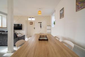 a living room with a large wooden table and chairs at Le Cocon Alsacien - Rez de chaussée - Parking privé in Ebersheim +1 photo