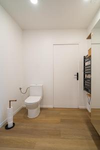a bathroom with a toilet and a white door at Le Cocon Alsacien - Rez de chaussée - Parking privé in Ebersheim