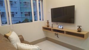 a living room with a flat screen tv on a wall at Suntrust Parkview Apartment in Manila