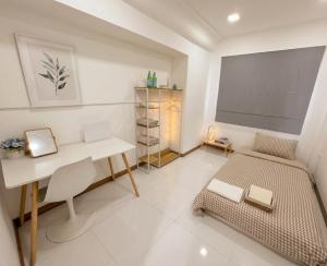 a room with a desk and a bed and a table at Huggdaily 6 in Ban Khlong Thewa