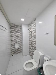 a bathroom with a toilet and a sink at Huggdaily 6 in Ban Khlong Thewa