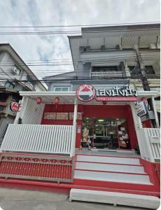 a restaurant with a red and white building at Huggdaily 6 in Ban Khlong Thewa