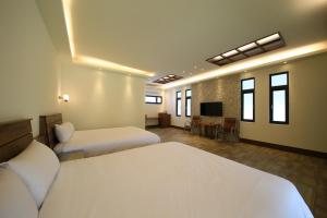 a hotel room with two beds and a television at Kenting Four Season Villa in Hengchun +26 photos