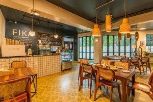 a restaurant with tables and chairs and a counter at Minimalist One Hauz Khas Village in New Delhi