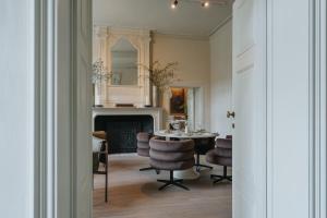 a dining room with a table and chairs and a fireplace at Roomer in Landen