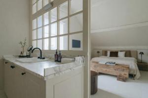 a bathroom with a sink and a bedroom with a bed at Roomer in Landen