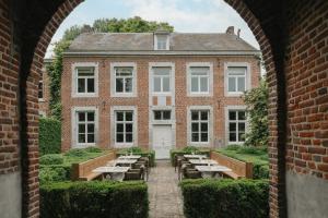 an external view of a brick building with tables and benches at Roomer in Landen