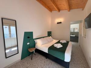 ein Schlafzimmer mit einem Bett, einem Spiegel und einem Fenster in der Unterkunft Isula Antica in Floridia