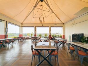 a dining room with tables and chairs and windows at Hotel Solaris in Indore