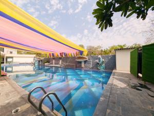 a swimming pool with a colorful umbrella over it at Hotel Solaris in Indore