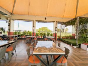 a restaurant with tables and chairs and large windows at Hotel Solaris in Indore