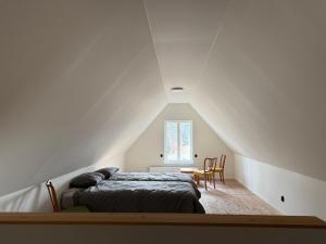 a bedroom with a bed and a table with chairs at Fiskarhuset - seaside cottage 4 pax in Sjöbo
