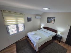 a bedroom with a bed with two pillows and a window at Panorama Apartment in Belgrade +30 photos