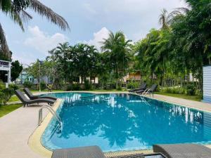 a large swimming pool with chairs and trees at Grand Luxe Kamala in Kamala Beach