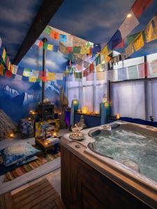 a bathroom with a jacuzzi tub with prayer flags at Au2 Maison d'Hôtes - Guest House Au2 in Muidorge