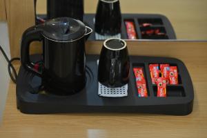a tray with a coffee pot and a tea kettle on it at Hotel Revanta Inn in Ahmedabad