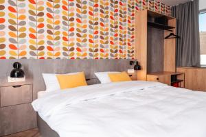 a bedroom with a large bed and a colorful wall at Urban Ring Hotel in Ljubljana +42 photos
