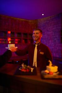 a man in a tie is shaking another mans hand at Wellness Hotel Chopok in Belá +88 photos