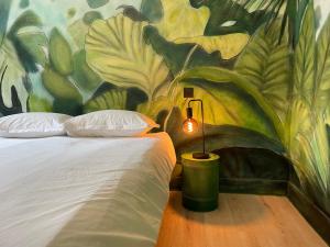 a bedroom with a painting of a bed and a lamp at Big Jungle in Grane