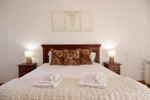 a bedroom with a bed with two towels on it at A Casa dos Príncipes in Amoreira +20 photos