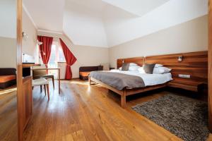 a bedroom with a bed and a desk and a table at Wellness Hotel Kager Harkány in Harkány