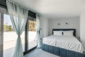a bedroom with a bed and a large window at My Sea Lodge - Glaros Complex in Pefkochori +10 photos
