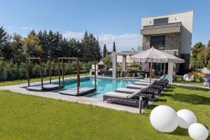 a swimming pool with lounge chairs and a house at My Sea Lodge - Glaros Complex in Pefkochori