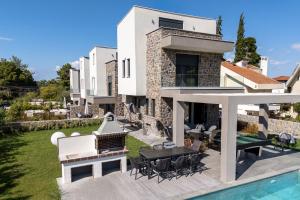 an external view of a villa with a swimming pool at My Sea Lodge - Glaros Complex in Pefkochori