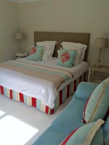 a bedroom with a large bed with two pillows at La Petite Baleine Seaside Villa in De Kelders