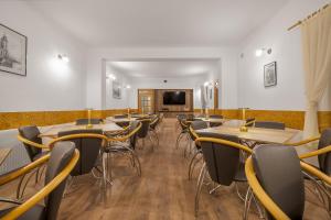 a room with tables and chairs and a flat screen tv at Pensiunea Kronstadt in Braşov
