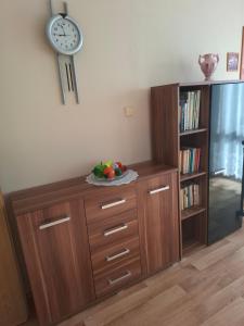 a wooden cabinet with a clock on the wall at Apartmány Prima-Pokoje in Mimoň