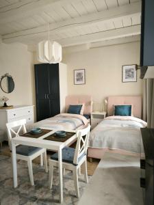 a bedroom with two beds and a table and chairs at Studio Apartment Self Check-in in Mažeikiai
