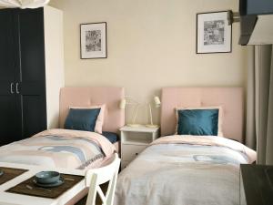 two beds sitting next to each other in a room at Studio Apartment Self Check-in in Mažeikiai
