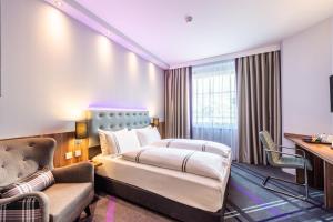 a hotel room with a bed and a desk at Premier Inn Essen City Limbecker Platz in Essen