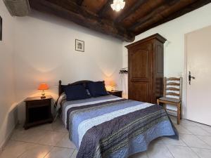 ein Schlafzimmer mit einem Bett, zwei Tischen und einem Stuhl in der Unterkunft Gorpulania in Arbonne