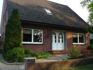 a red brick house with a white door at Ferienwohnung zum Pferdeblick in Bad Bentheim