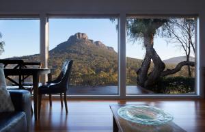 a living room with a view of a mountain through a window at Mereweather Estate Cottage in Dunkeld