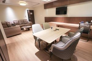 a room with a table and chairs and a couch at SKYLAR Tirupati in Tirupati