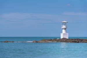 a lighthouse on a small island in the water at Kokotel Khao Lak Seascape in Khao Lak +18 photos