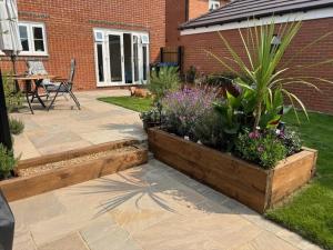 a garden with a patio with a table and some plants at Quiet double bedroom in Yapton +2 photos