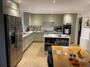 a kitchen with green cabinets and a wooden table at Quiet double bedroom in Yapton