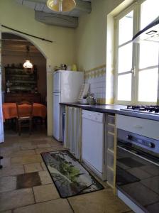 a kitchen with a white refrigerator and a table at Gîte robale in Romagne