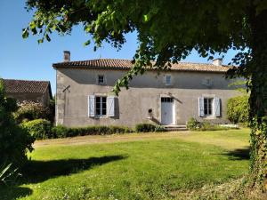 an old stone house with a green yard at Gîte robale in Romagne